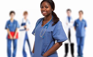 Portrait of a smiling nurse in front of a group of doctors