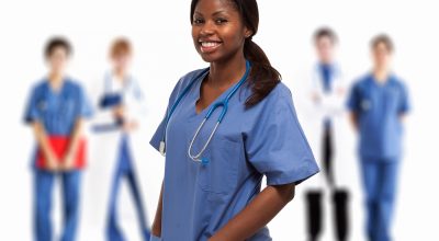 Portrait of a smiling nurse in front of a group of doctors