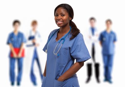 Portrait of a smiling nurse in front of a group of doctors