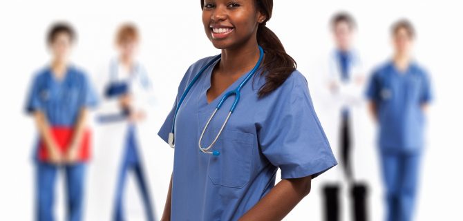 Portrait of a smiling nurse in front of a group of doctors