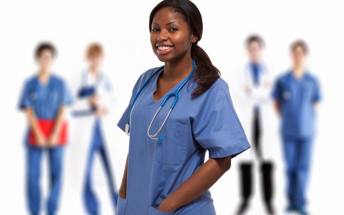 Portrait of a smiling nurse in front of a group of doctors